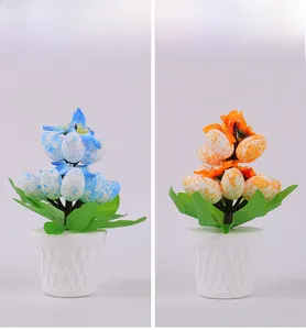 Detail view of artificial Easter egg potted plants with speckled eggs and colorful flowers