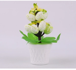 Close-up of Easter egg bonsai with yellow flowers and green spotted foam eggs