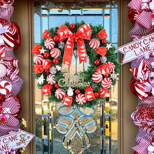 Christmas wreath with red and white candy cane ornaments and Merry Christmas sign on door