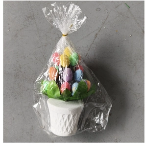 Detail view of colorful Easter egg bonsai decoration in a white textured pot with leaves