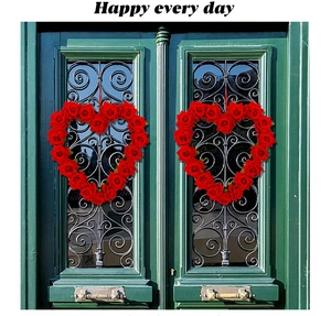 Close-up of dual heart-shaped red rose wreaths on a dark green vintage door decoration