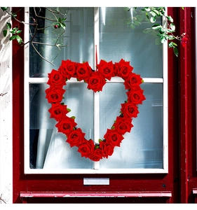 Detail of red silk roses heart-shaped wreath hanging with a silk ribbon for Valentine decoration