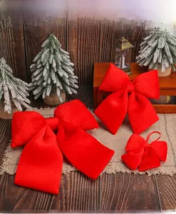 Close-up of red velvet festive bows in various sizes on a rustic wooden background