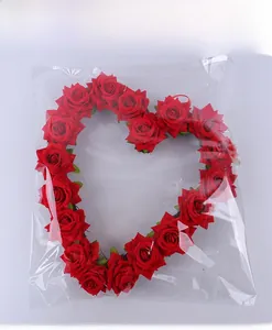Macro shot of heart-shaped red rose wreath in clear protective plastic packaging