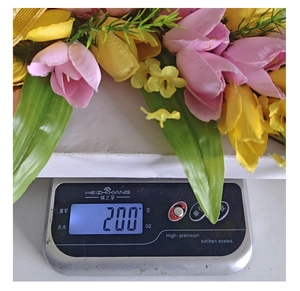 Detailopname van een Pasen tulp kruis krans die 200g weegt op een digitale weegschaal