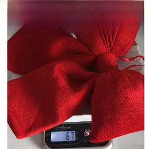 Detailed close-up showing a large red velvet New Year bow weighing 67g on a digital scale