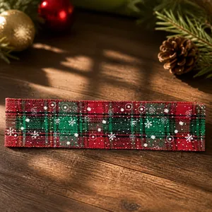 Détail du ruban de Noël à carreaux rouge et vert avec des motifs de flocons de neige