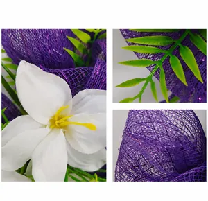 Detailed view of Easter wreath featuring white faux flowers and purple deco mesh ribbon