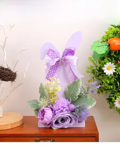 Detailed view of a purple Easter bunny floral ornament with faux roses on a wooden base