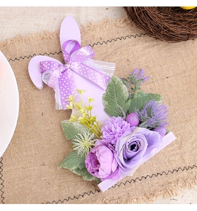 Close-up of Easter bunny ornament with purple faux flowers and ribbon on burlap