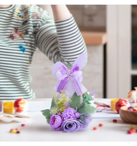 Detail of Easter bunny ornament with purple ribbon and faux floral arrangement