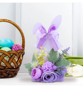 Detail of purple Easter bunny centerpiece with decorative silk flowers and ribbon bow