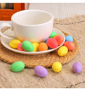 Œufs de Pâques colorés à taches dorées sur tissu beige et dessous de plat tressé