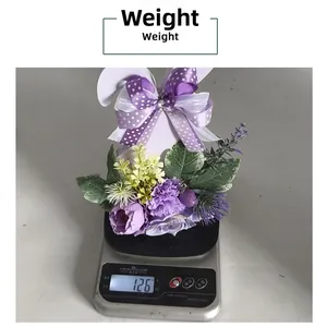 Detailed view of purple Easter floral centerpiece weighing 126g on digital scale