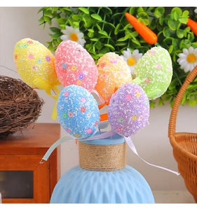 Détail d'œufs de Pâques colorés en mousse avec rubans dans un vase bleu