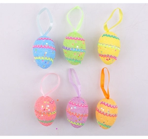 Detalle de huevos de Pascua colgantes de espuma con lentejuelas y cintas decorativas