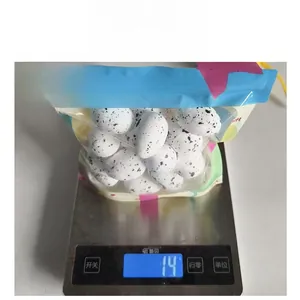 Vue détaillée d'œufs de Pâques en mousse tachetés dans un emballage cadeau pesés sur balance