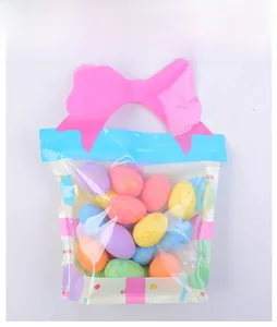 Sac cadeau transparent avec nœud rose rempli d'œufs de Pâques colorés en mousse