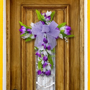Paaskruiskrans met paarse tulpen en jute strik hangend aan een houten voordeur
