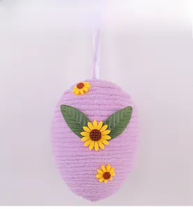 Close-up of a purple Easter egg decoration with yellow sunflowers and a silk hanging ribbon