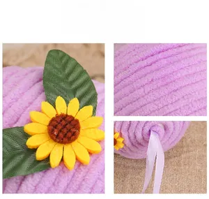 Detail of purple velvet Easter egg featuring knitted sunflower, green leaf and silk ribbon