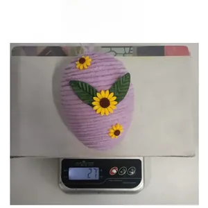Detail view of a 27g hand-woven purple Easter egg ornament featuring yellow sunflower accents