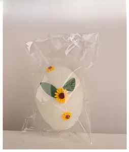Detailed view of handmade plush Easter egg decoration in protective clear packaging