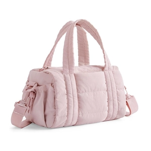 Gros plan du tissu en nylon rose matelassé et de la poche latérale du sac bandoulière