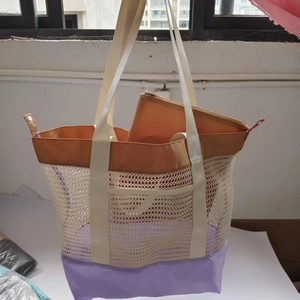 Detail of beige mesh tote bag with purple base and inner zippered pouch for storage