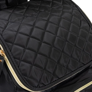 Vue détaillée du tissu en nylon noir matelassé imperméable et des fermetures éclair dorées