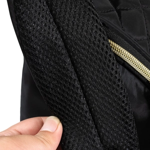 Détail de la bandoulière en maille rembourrée et fermeture éclair dorée du sac à langer