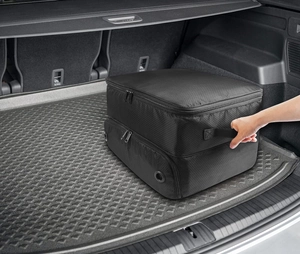 Detail of black golf shoe bag featuring honeycomb texture and reinforced handle in a car trunk