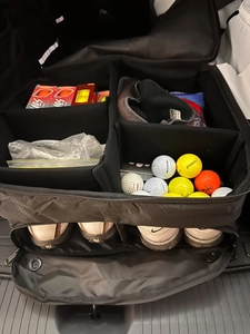 Detail view of ventilated golf shoe compartment and adjustable storage dividers in black bag