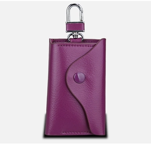 Detailansicht der dunkelvioletten Leder-Schlüsseltasche mit silbernem Karabiner und Druckknopf