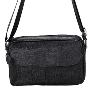 Close-up of black lychee grain leather crossbody bag with silver buckle and zipper