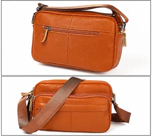 Detail view of brown pebbled leather crossbody bag showing dual zipper compartments and strap