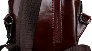 Detail der weinroten Ledertasche mit Metall-D-Ring und robustem Schultergurt-Haken