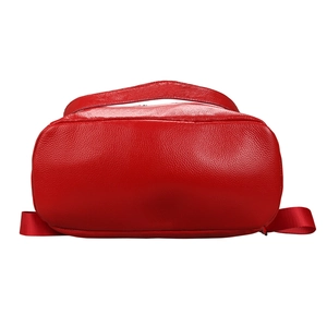 Vue macro du fond du sac à dos en cuir rouge montrant la texture grainée et couture