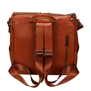 Détail d'un sac à dos en cuir marron avec bretelles réglables et zips métalliques