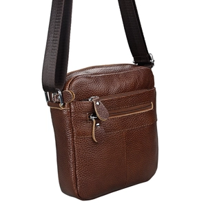 Side view of dark brown pebbled leather crossbody bag with front zipper pocket
