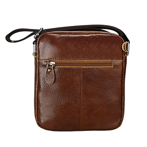 Detail of genuine brown leather crossbody bag featuring lychee texture and zipper pocket
