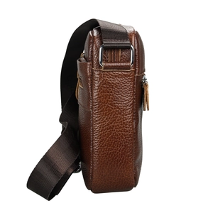 Detail view of brown pebbled leather texture and metal strap rings on men's crossbody bag