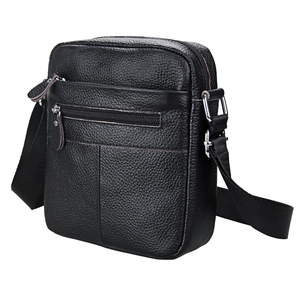 Detail view of black leather crossbody bag featuring lychee texture and silver metal hardware