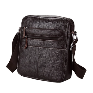 Detailed view of dark brown pebbled leather shoulder bag with multiple front zippers