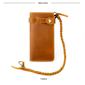 Detail of vintage brown leather long wallet with woven security chain and brass buckle