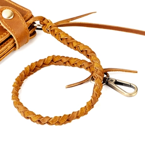 Detail of hand-woven brown leather wallet lanyard with vintage bronze lobster clasp