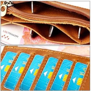 Macro detail of brown leather wallet featuring multiple card slots and a metal zipper pocket