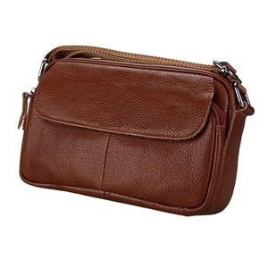 Detail of dark brown pebble grain leather crossbody bag with multiple zip compartments
