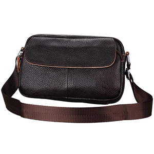 Detail of genuine leather messenger bag with pebble grain texture and wide woven strap