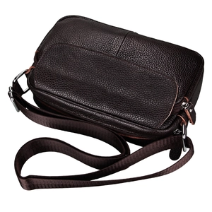 Macro detail of dark brown pebble grain leather texture and silver metal hardware zippers